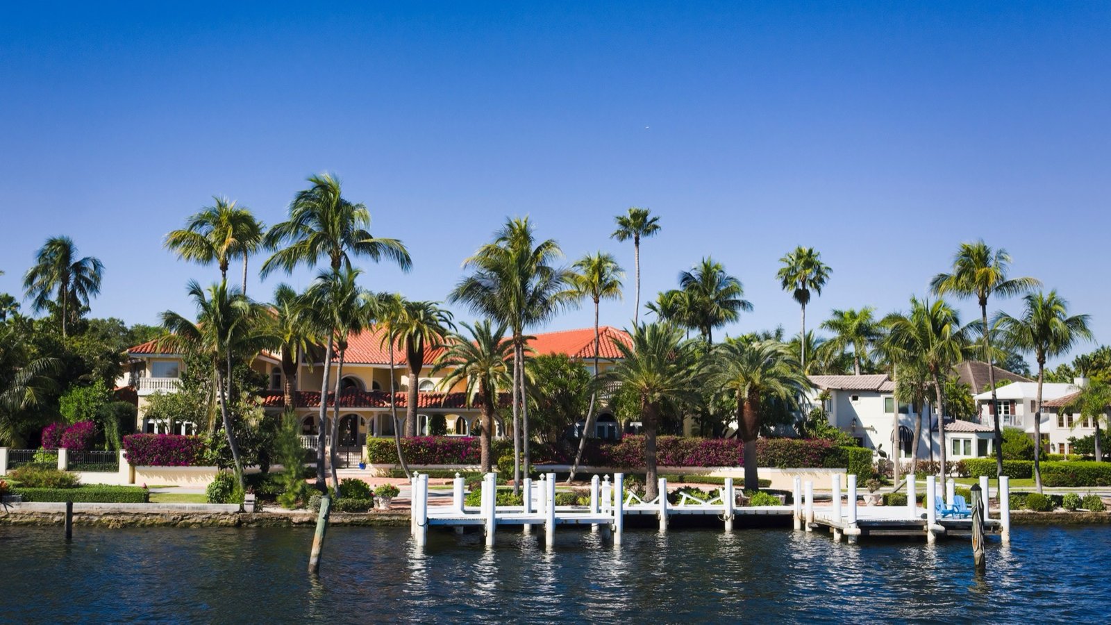 Waterfront estate with private dock and palm trees